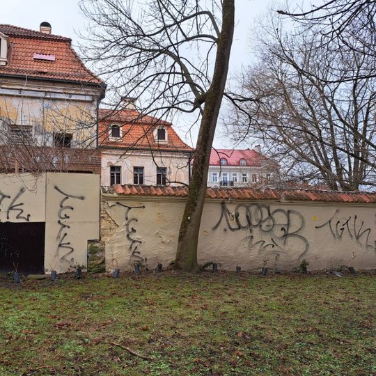 Kirdiejų rūmų siena su skyle ir įvairiais grafiti užrašais Pilių parke.