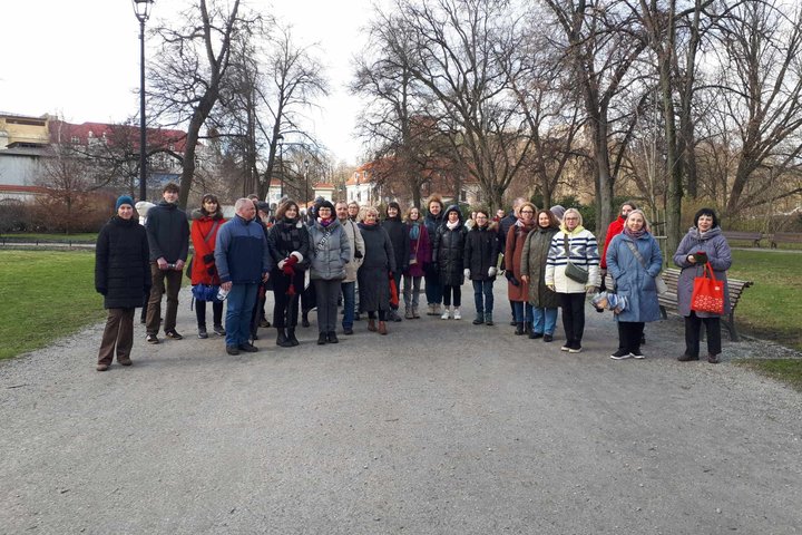 Ekskursijos grupė stovi Bernardinų sode. Šypsosi.