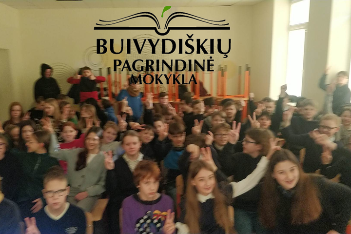 Nuotraukoje - Buivydiškių pagrindinės mokyklos ženklas ir pilna klasė stovinčių vaikų.