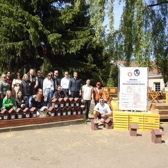 Inkilėlių kabinimo šventės dalyviai ir organizatoriai su išrikiuotais inkilais.