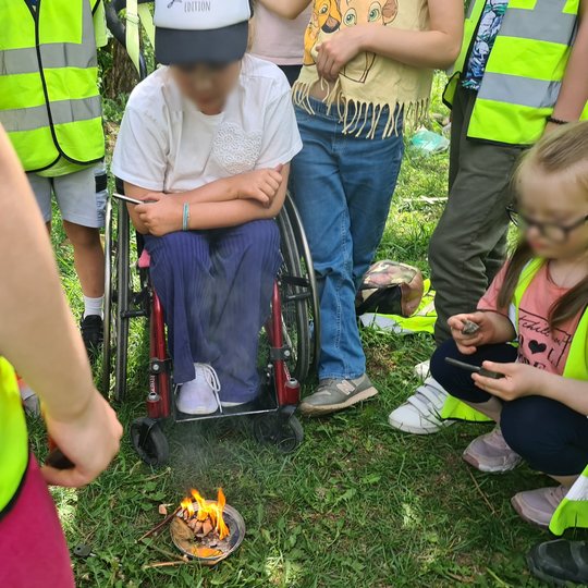Mokiniai smalsiai prižiūri jų uždegtą lauželį ant Stalo kalno.