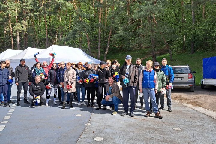 Trisdešimties BTA draudėjų komanda su priemonėmis stovi estradoje, pasiruošę dirbti.