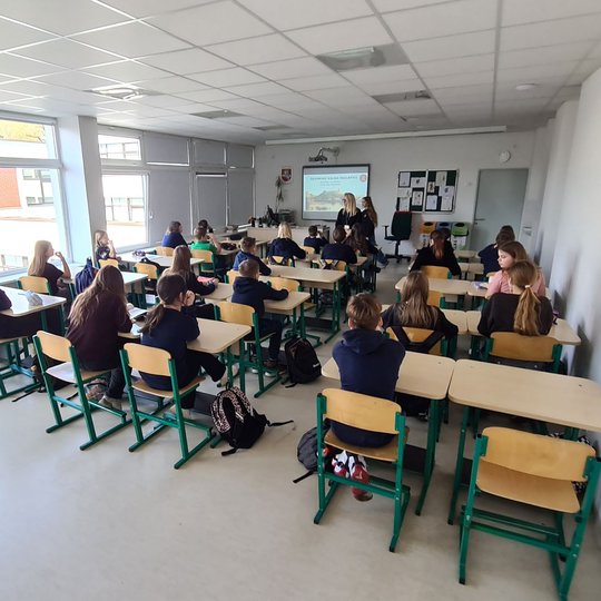 Iš galo nufotografuota, kaip mokiniai klausosi jiems dėstomos edukacinės pamokos.