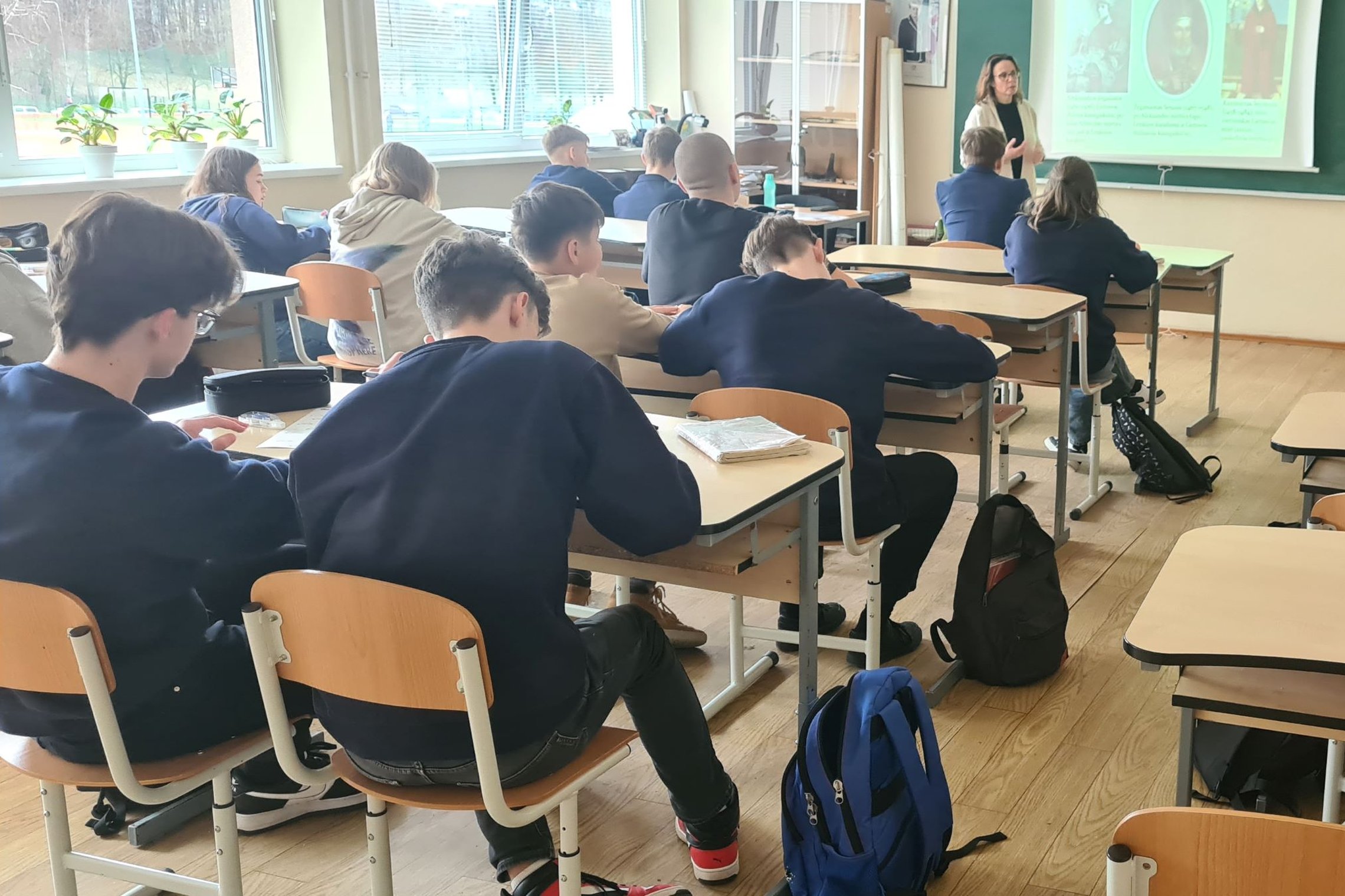 Edukatorė veda istorijos pamoką aštuntokams.