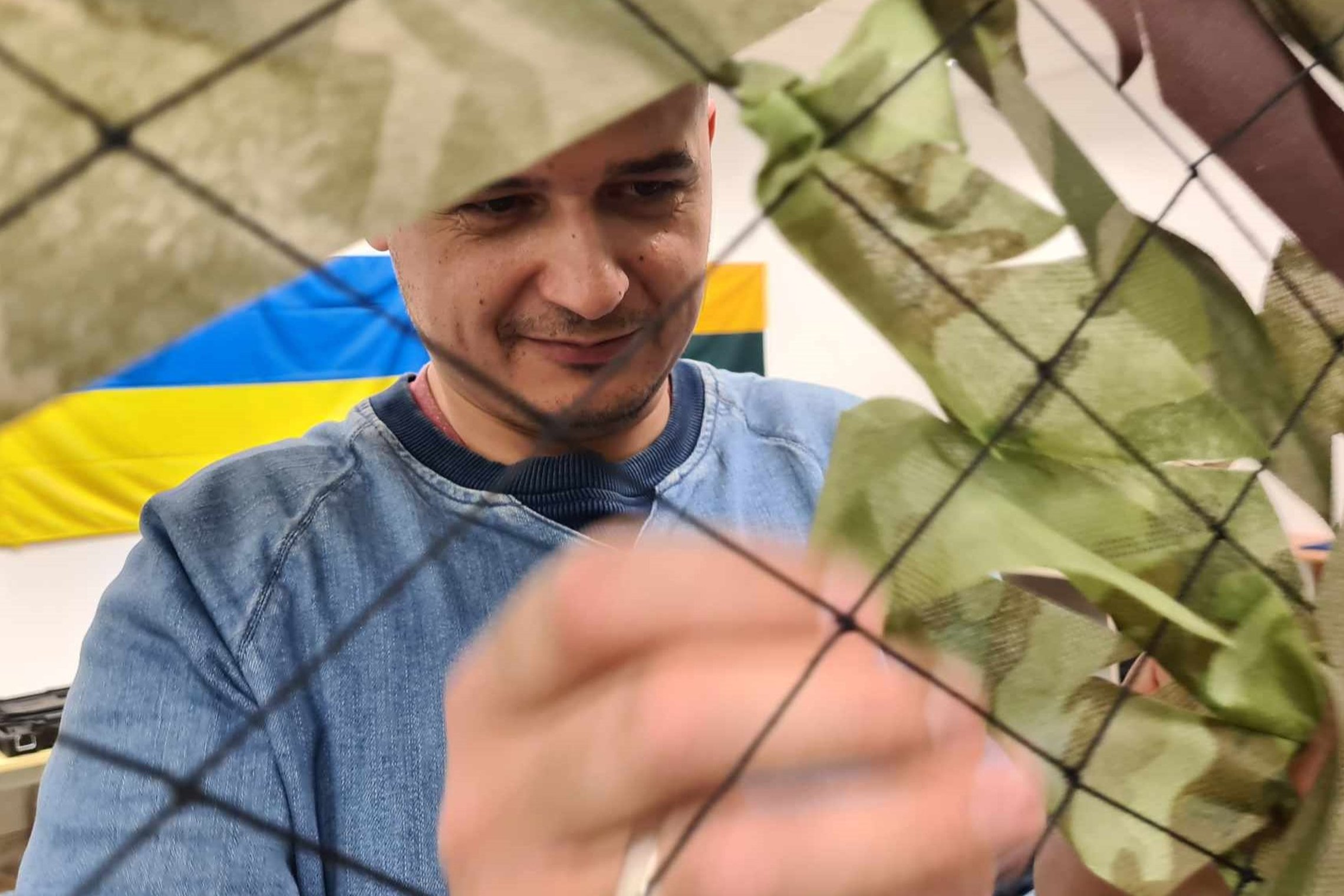 Direkcijos darbuotojas nufotografuotas per rišamo tinklo tarpą.