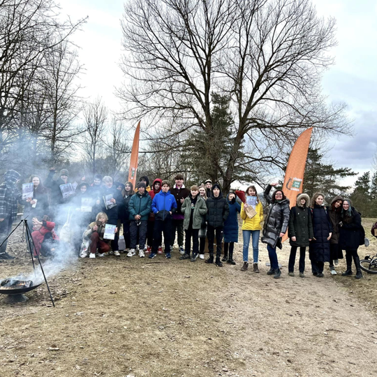 Bendra visų dalyvavusių žygyje ir apdovanotų turistų nuotrauka ant Stalo kalno prie rūkstančio laužo.
