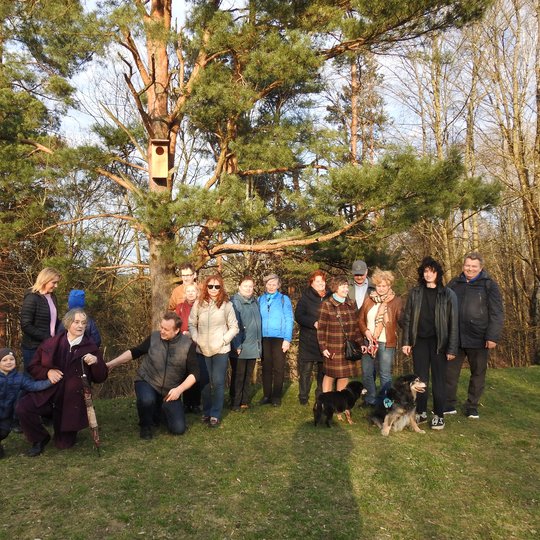 Inkilą rezervatui dovanojusi grupė žmonių susirinko ir su pora augintinių - šunų. Nuotraukoje visi susirinkę prie įkelto inkilo.