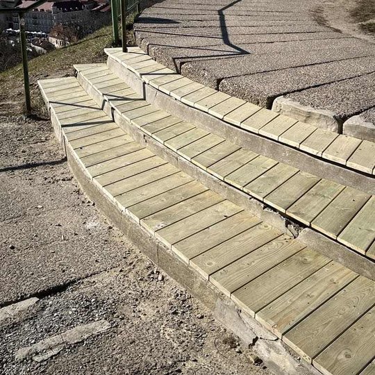 Betoniniai laiptai apkalti medienos lentomis. Nuotraukoje mediena dar nedažyta.