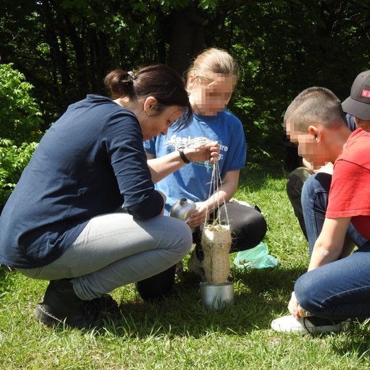 Vaikai mokosi išvalyti vandenį lauko sąlygomis, kad jis būtų tinkamas atsigerti.