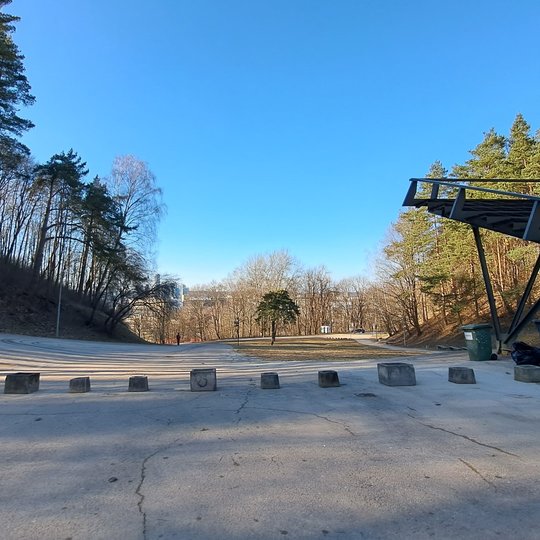 Nuotraukoje betoniniai lauko vazonai, pastatyti per estrados įvažiavimą.