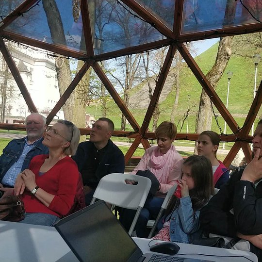 Vilniaus pilių kupole susirinkę žmonės sėdi ir įdėmiai klausosi paskaitos apie skalikus.