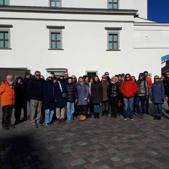 Ekskursijos dalyvių grupė prie Valdovų rūmų sienos.