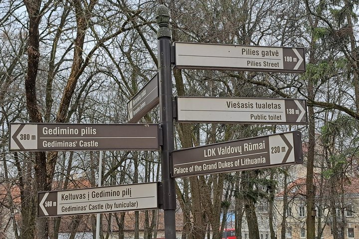 Nukreipiamosios rodyklės Sereikiškių parke. Tarp jų matosi ir sutvarkyta rodyklė, rodanti kryptį viešojo tualeto link.