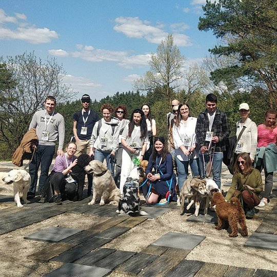 Trečia grupė susirinkusių dalyvių su savo šunimis išsirikiavę ant Karigailos kalvelės.