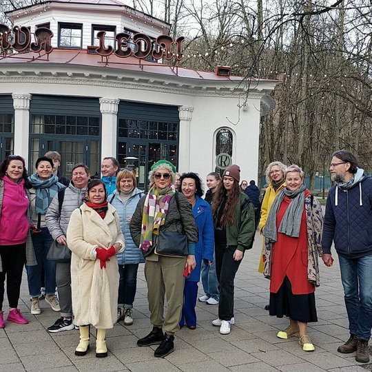 Dalyvių kompanija nuotraukoje stovi prie "Rotondos" kavinės Pilių parke.
