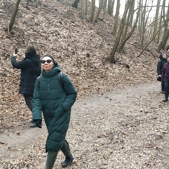 Vilniaus technologijų ir dizaino kolegijos ekskursantai besišnekučiuodami eina Didžiąja griova ir fotografuoja aplinką.