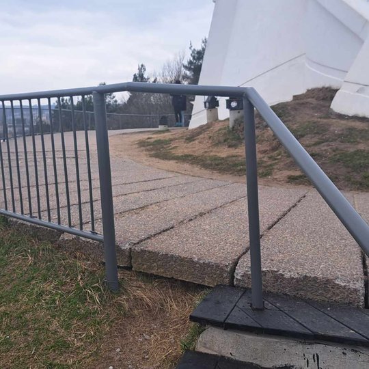 Nufotgorafuoti apžvalgos aikštelės turėklai. Jie nudažyti pilka spalva.