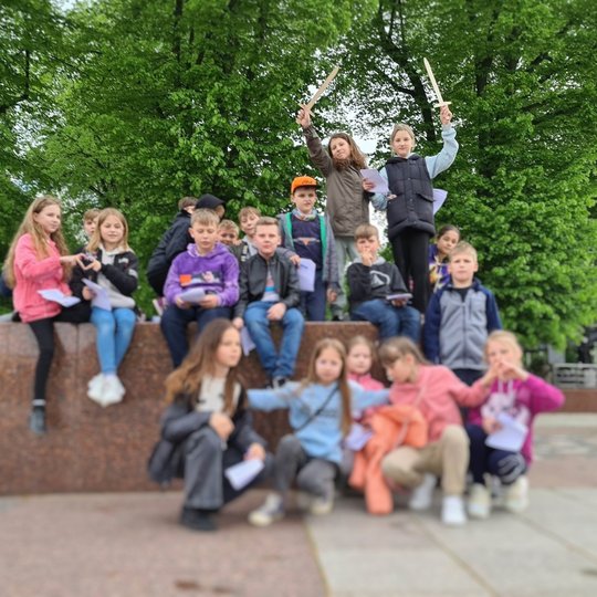 Ketvirtokai pozuoja išsirikiavę prie Pilių parko plokštės, žyminčios buvusius vartus.