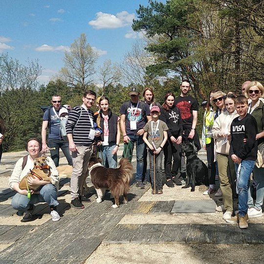 Ketvirta grupė dalyvių su augintiniais stovi ant Karigailos kalvelės. Susirinko įvairaus amžiaus žmonės.