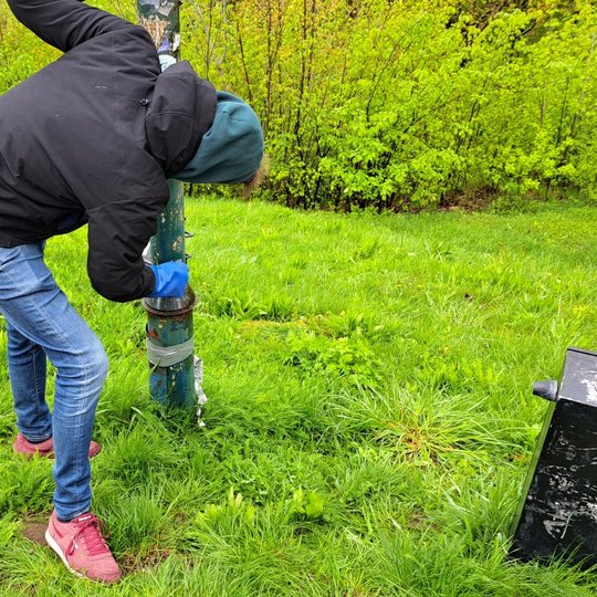 Savanoris valo apipieštą ir išdažytą šviestuvo stulpą ant Trijų kryžių kalno.