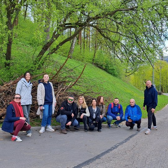 Dešimt Avia Solutions Group savanorių prie vienos iš surinktų šakų krūvų.