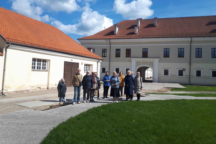 Trečiojo amžiaus universiteto studentai nufotografuoti muziejaus kieme, prie buvusios bažnyčios pamatų.