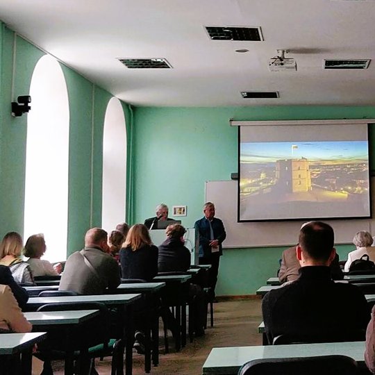 Jonas Satkūnas pradeda seminarą. Auditorijoje susirinkę žmonės klausosi.