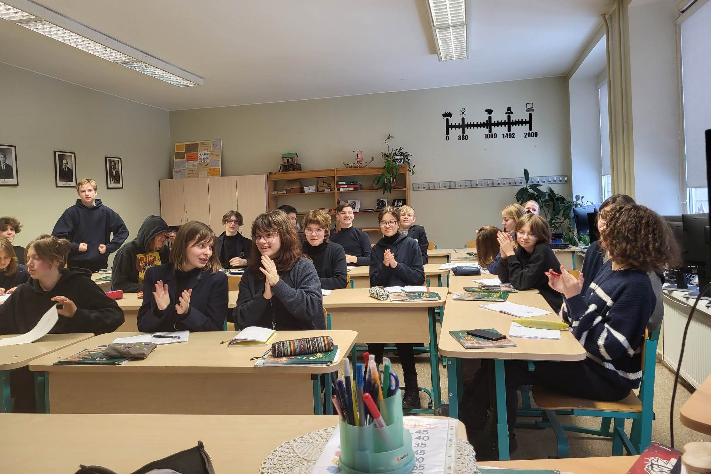 Aštuntokai, sėdėdami suoluose, ploja po pamokos apie marą. 