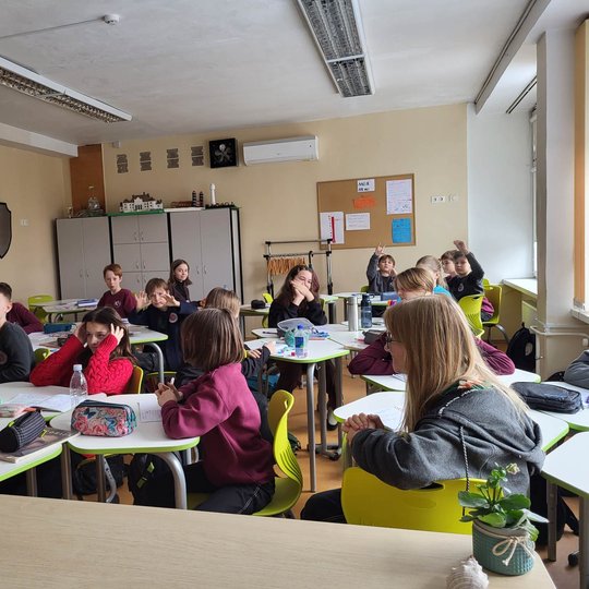 Mokiniai klasėje atidžiai klausosi pamokos.