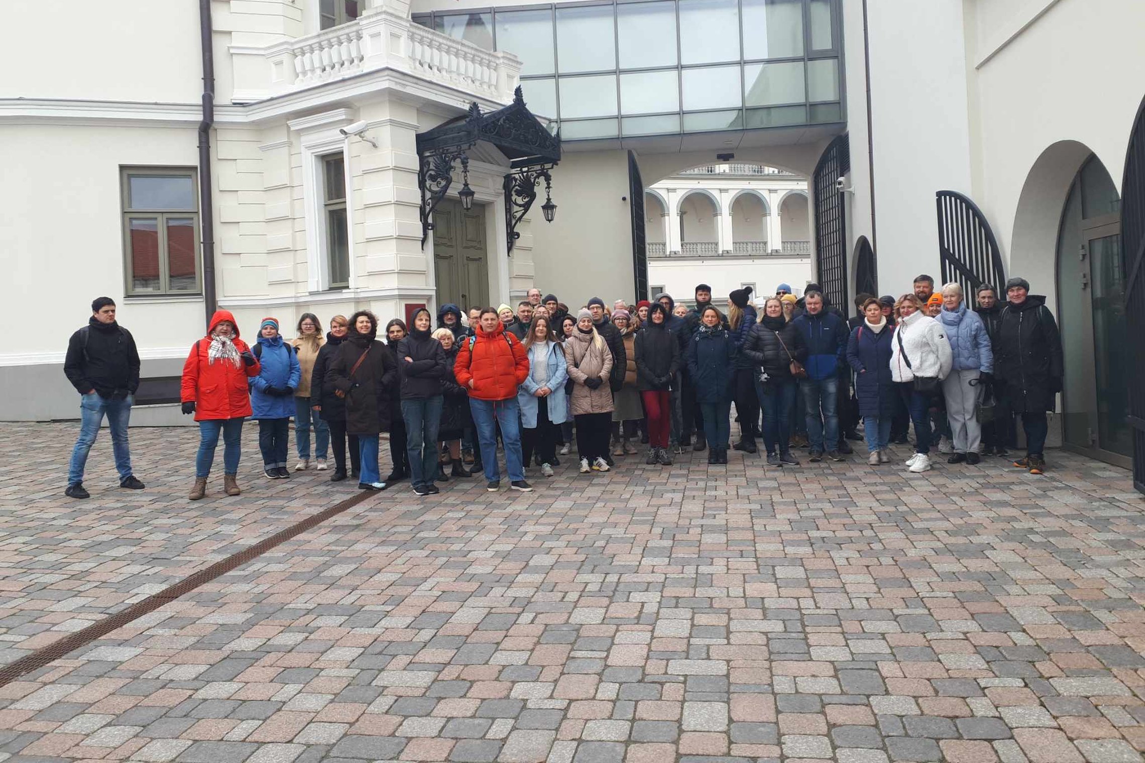 Ekskursijos dalyvių būrys vos telpa nusifotografuoti prie Valdovų rūmų kiemo vartų.