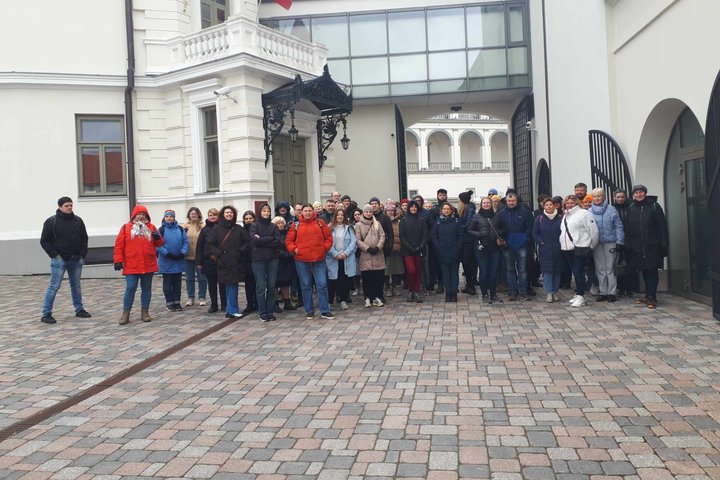 Ekskursijos dalyvių būrys vos telpa nusifotografuoti prie Valdovų rūmų kiemo vartų.