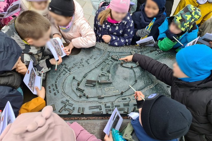 Mokinukai prie metalinio Vilniaus pilių maketo.