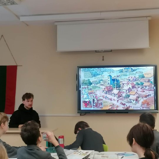 Edukatorius mokiniams pasakoja apie gyvenimą kaime viduramžiuose.