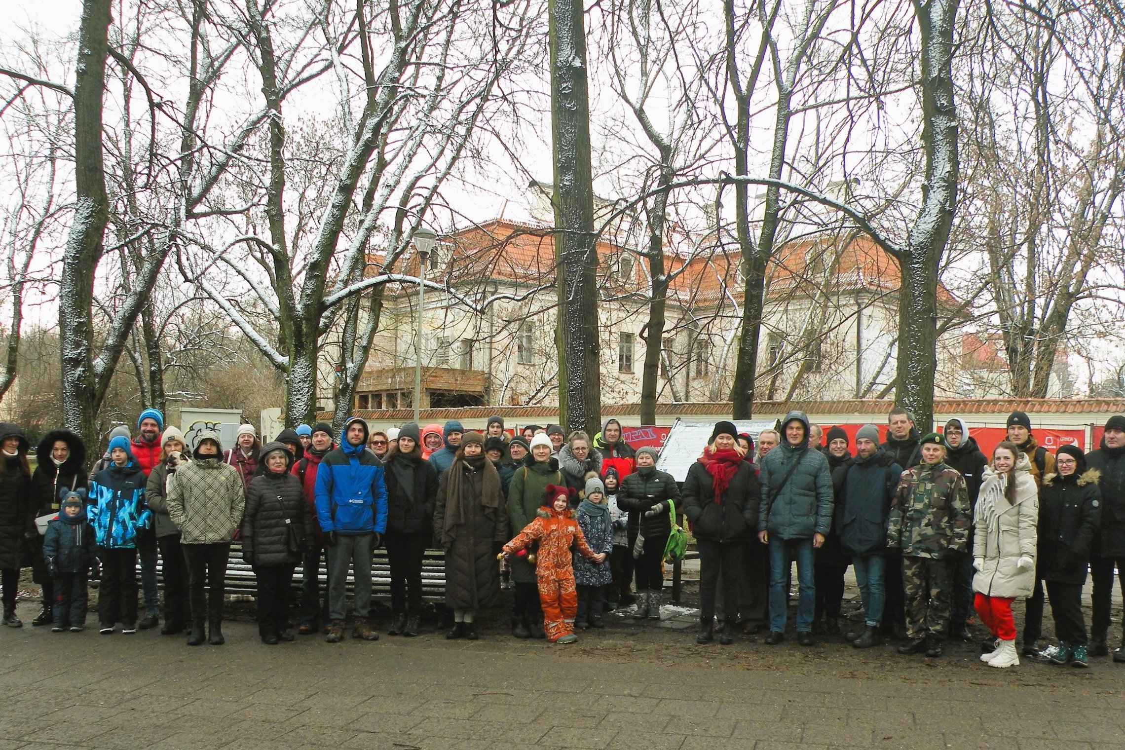 Gausus ekskursijos dalyvių būrys pozuoja nuotraukai pilių parke.  