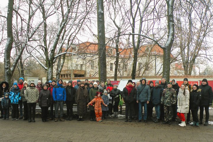 Gausus ekskursijos dalyvių būrys pozuoja nuotraukai pilių parke.