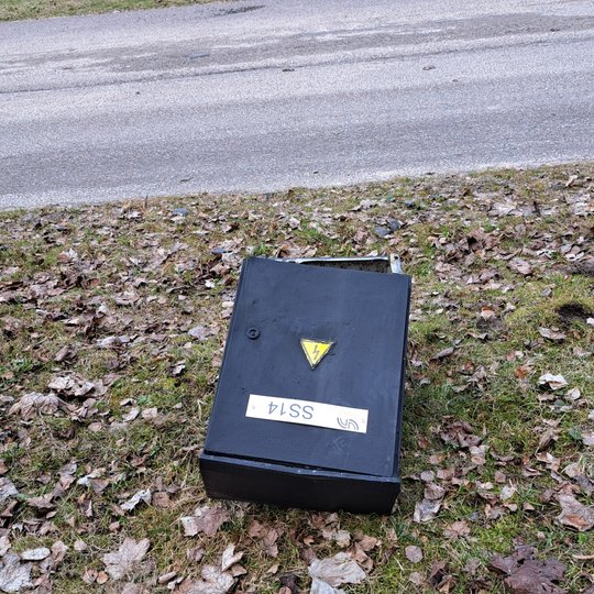 nufotografuota nuversta į šoną elektros skydinė. iš jos išlindę elektros laidai.