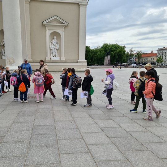Vaikučiai keliauja Katedros fasado link, nuo varpinės.