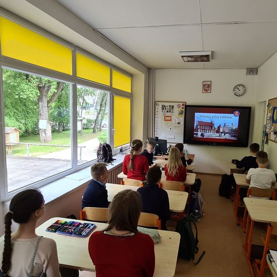 Maža ketvirtokų klasė, fotografuota iš galo. Vyksta pamoka apie Vilniaus pilių valdovus.