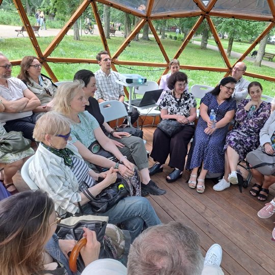 Žmonės sėdi Vilniaus pilių kupole ir stebi prezentaciją.