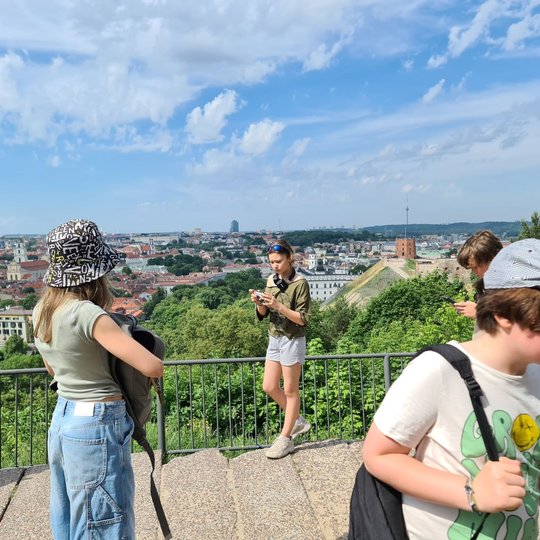 Keturi mokiniai ant Trijų Kryžių kalno apžvalgos aikštelės.