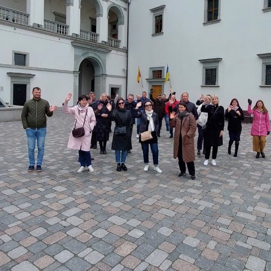 Ekskursijos dalyviai mojuoja iš Valdovų rūmų kiemo.