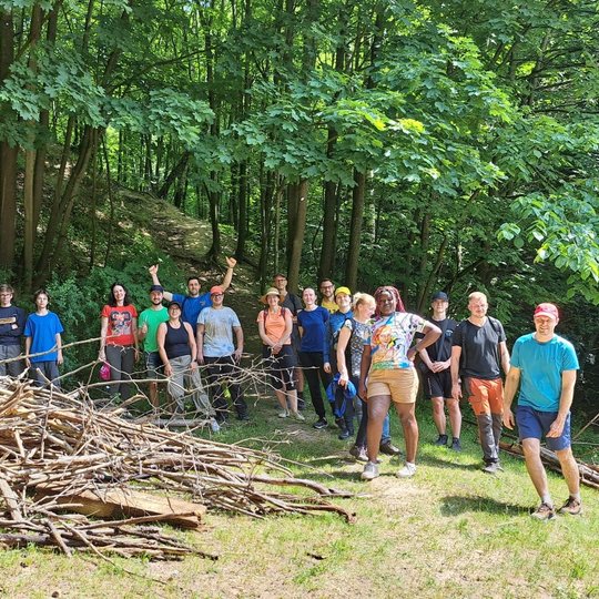 Savanoriai nusifotografavo atlikę veiklą, prie surinktos vėjovartų krūvos.
