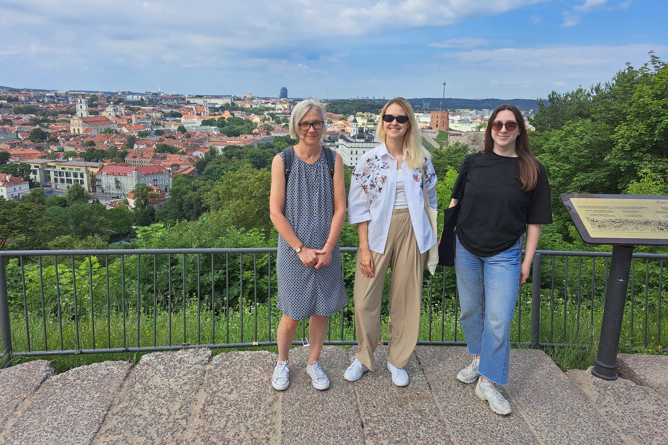 Trys moterys stovi Trijų Kryžių kalno apžvalgos aikštelėje.