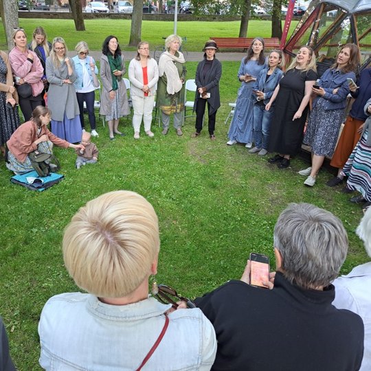 Moterys Sereikiškių parke, sustoję ratu, dainuoja sutartines.