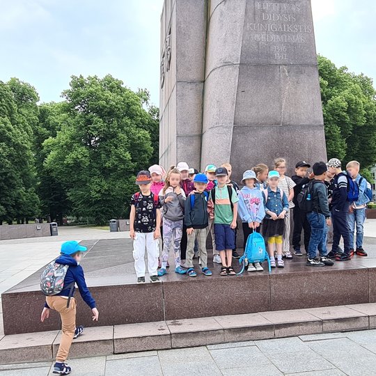 Grupė vaikų sustojo ant Gedimino paminklo plokštės.