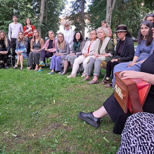 Moterys Sereikiškių parke, susėdę ratu, dainuoja sutartines.