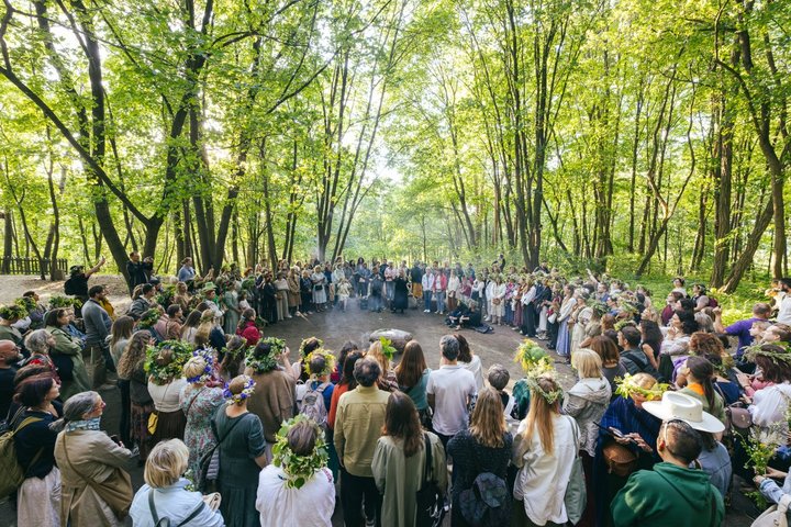 Didelis būrys žmonių stovi ratu aplink Trijų Kryžių kalne esantį aukurą.