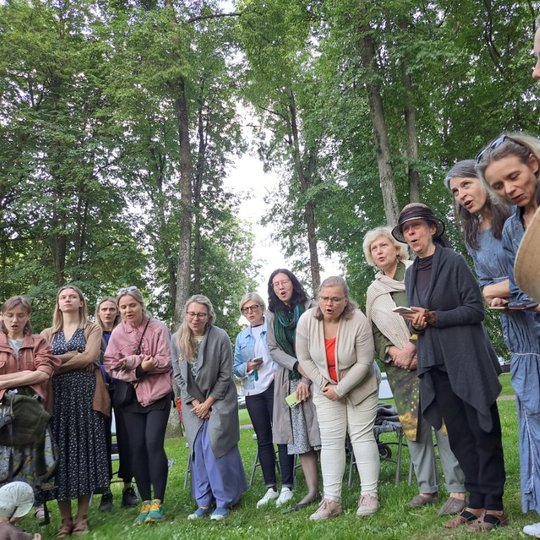 Moterys Sereikiškių parke, sustoję ratu, dainuoja sutartines.