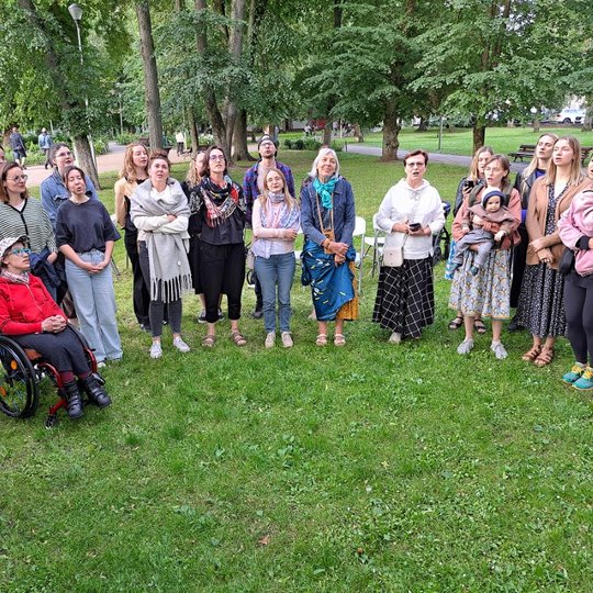 Moterys Sereikiškių parke, sustoję ratu, dainuoja sutartines.