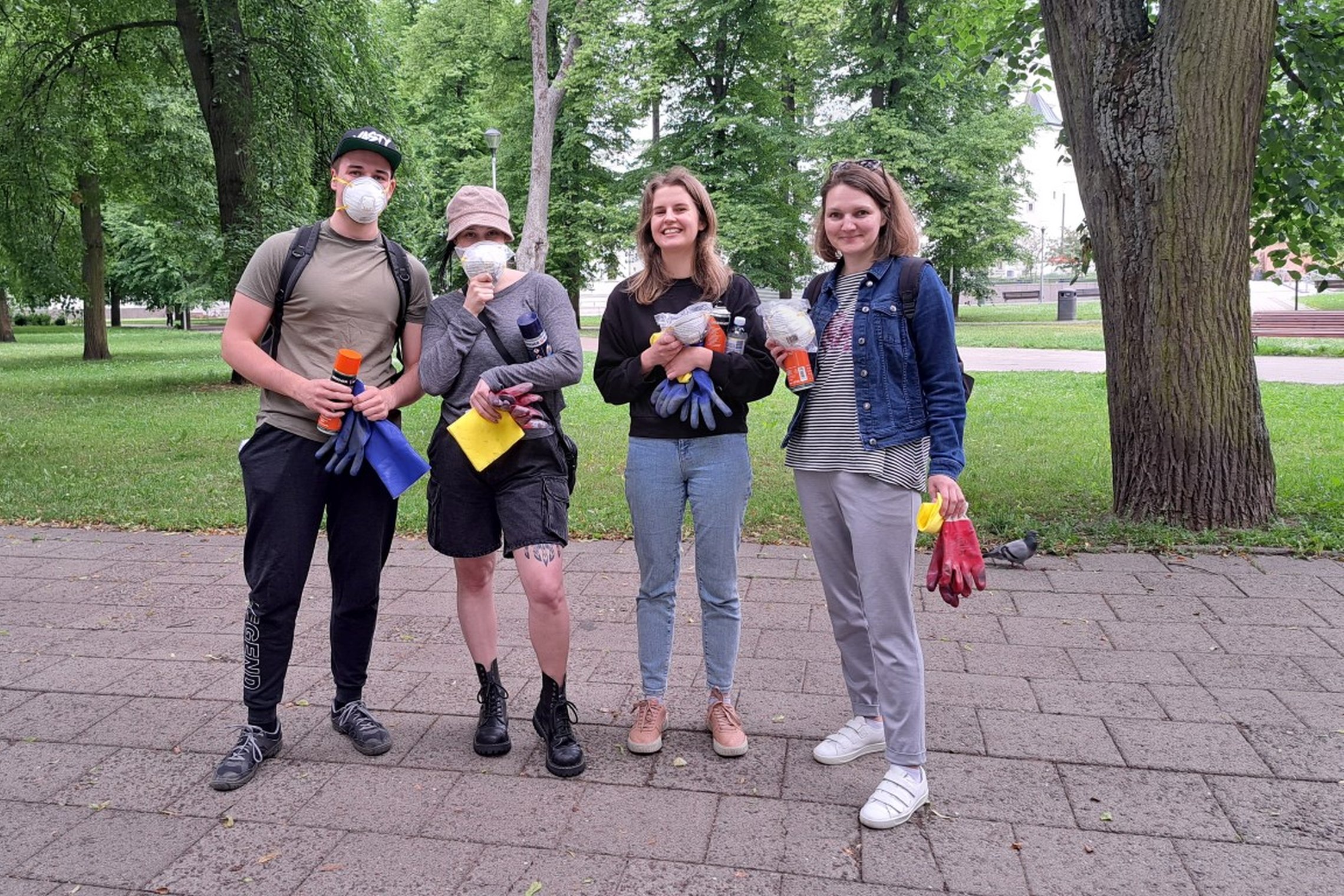 Keturi SEB banko savanoriai, su priemonėmis graffiti valymui, sustoję Sereikiškių parke.